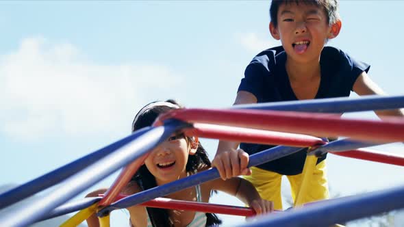 Schoolkids playing on dome climber in playground