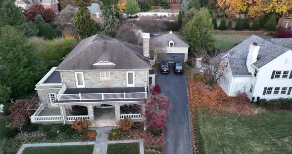 Aerial establishing shot of upscale home in USA. Cold autumn scene with slo motion smoke from chimne