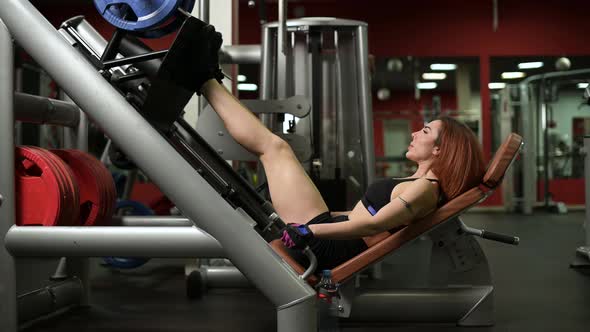 young woman exercising her legs on a platform press machine