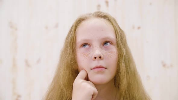 Portrait Red Haired Girl with Freckles Looking Thoughtfully in Light Studio. Close Up Face Thinking