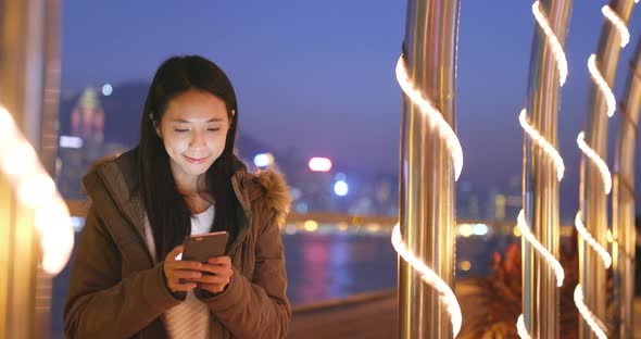 Woman Use of Smart Phone in The City at Night, Urban Cityscape Background of Hong Kong