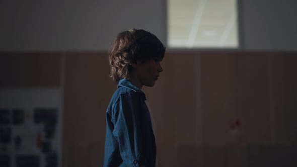 Upset Schoolboy Walking Empty Campus Corridor Alone