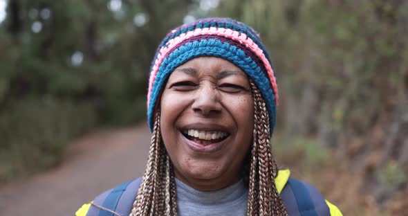 African senior woman smiling on camera during hiking day