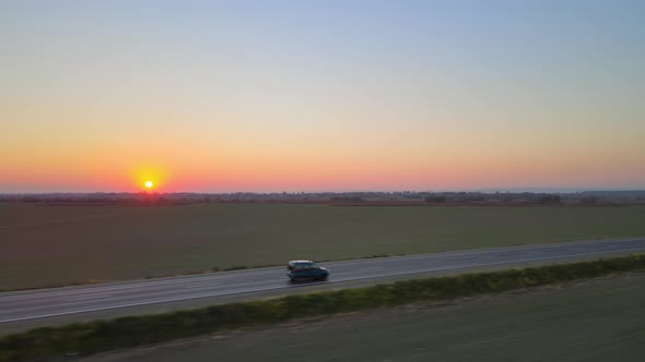 Aerial View of Intercity Road with Fast Driving Cars at Sunset