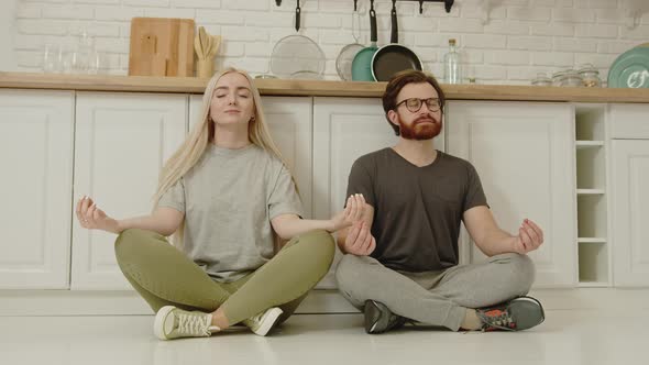 Happy Caucasian Couple Meditating on Quarantine in Their Modern Apartment Taking Care of Physical