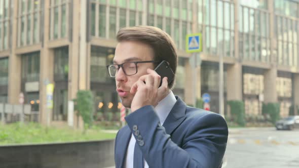 Businessman Getting Angry on Call while Walking in Street
