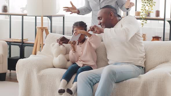 Afro American Family Little Black African Daughter Child Girl Sitting on Couch with Father Playing