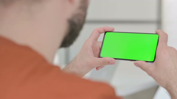 Young Man Watching Smartphone with Chroma Screen
