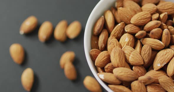 Video of fresh fruit almonds in a bowl on grey background