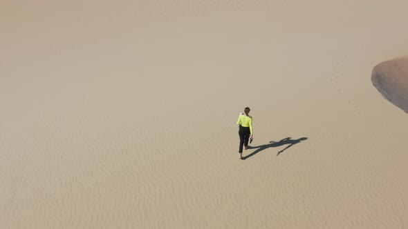 Back View of Woman in Black Neon Warrior Costume VR Glasses in Sand Dunes