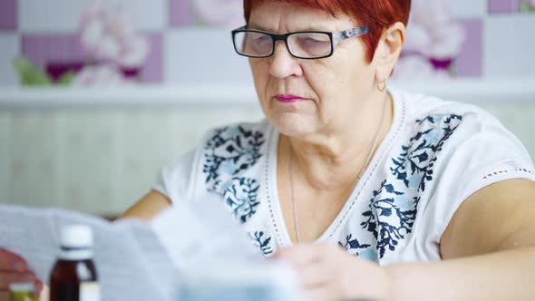 Senior Woman Reading Instruction To Medicine