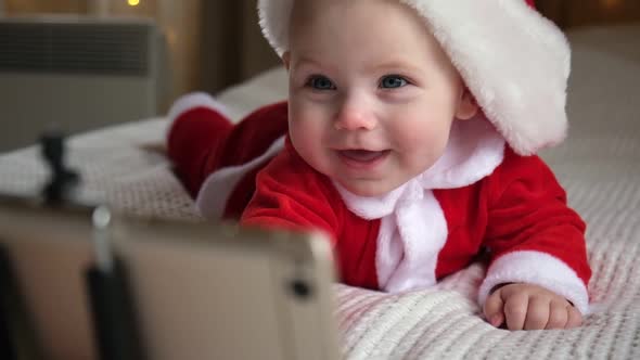 Smiling Baby Wearing Red Santa Claus Costume Making Video Call