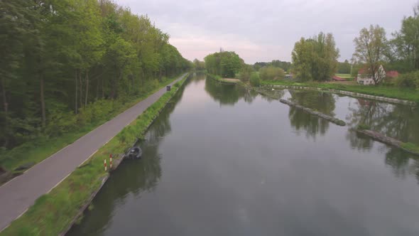 Aerial Footage Traveling Along a Canal Bordered By Trees