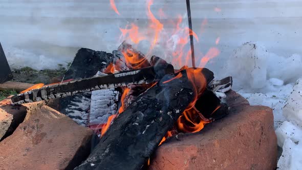 A Burning Fire with Coals Over Which Hangs a Tourist Pot in Winter