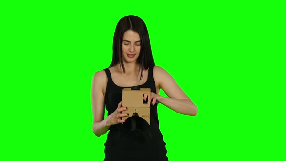 Young Woman with VR Virtual Reality Headset on Her Head, Green Screen