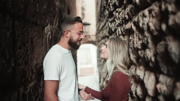 Couple Standing On A Narrow Alley Simultaneously Stares Into Each Other. medium shot