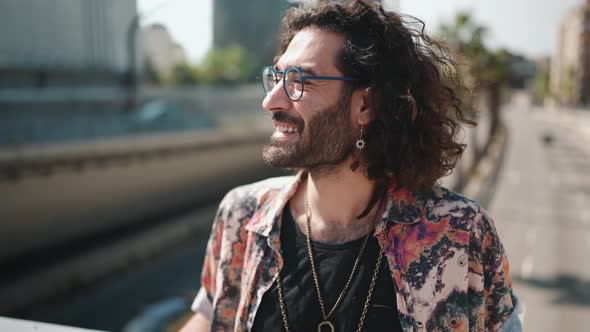 Cheerful curly-haired bearded man in eyeglasses looking around