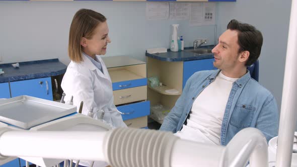 Female Dentist Greeting Male Patient at Clinic