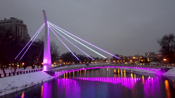 Illuminated bridge on winter river in Kharkiv city