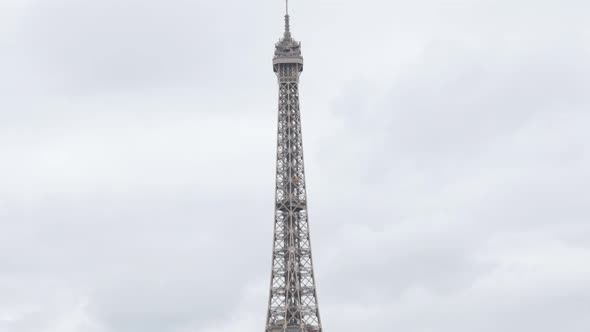 Tilting on Eiffel tower and symbol of France in front of cloudy sky 4K 2160p UltraHD footage - Paris