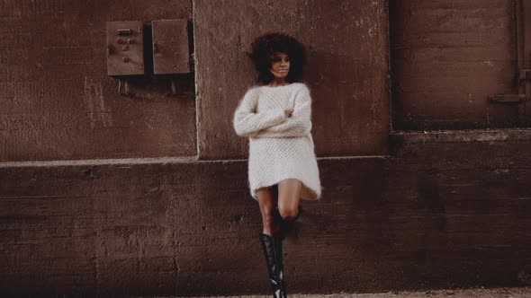 Young Model Leaning Against Wall In Woollen Top And Boots
