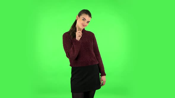 Girl Listens Carefully, Threatens with a Finger Seductively. Green Screen