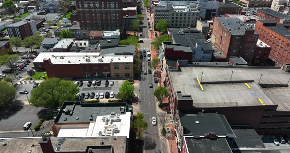 Urban city in USA on sunny day. Aerial tilt up reveal above street traffic.