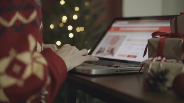 Woman Using Laptop To Shop For Gifts In Christmas