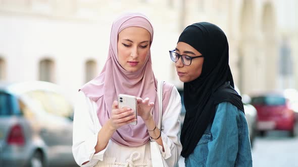 Beautiful arabian women wearing national hijab is using online map on the mobile