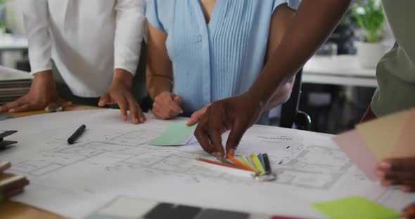 Hands of diverse businesswomen working together in office, deciding colour palette