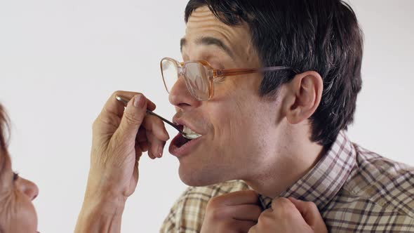 Mom Feeds an Adult Son Out of a Spoon