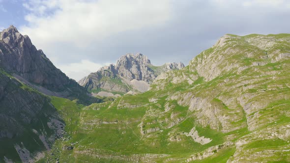 Happy Couple of Tourists Reaching the Summit While Hiking in Mountain Bobotov Kuk in Durmitor