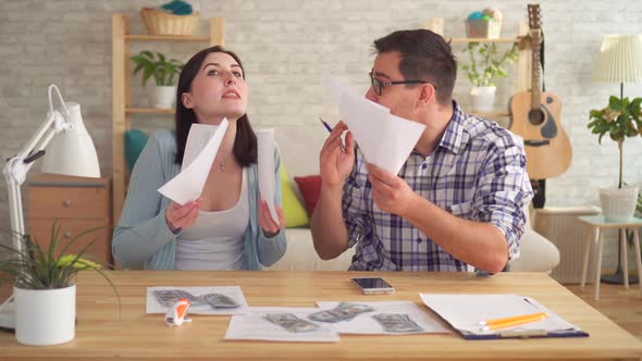 Young Couple Quarrels While Making Calculations of Documents at Home with a Calculator