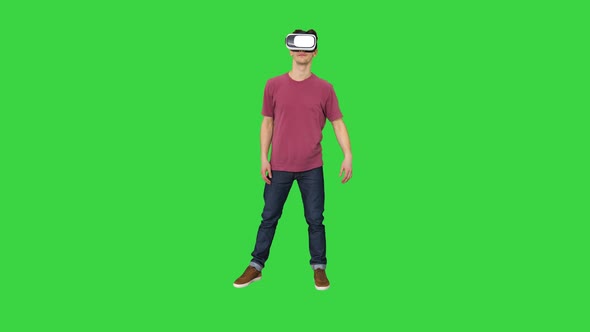 Casual Man in VR Glasses Dancing Playing Video Game Beginners Level on a Green Screen, Chroma Key.