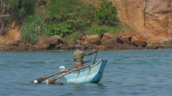 Fisherman with Rod in Traditional Wooden Boat with Balancer