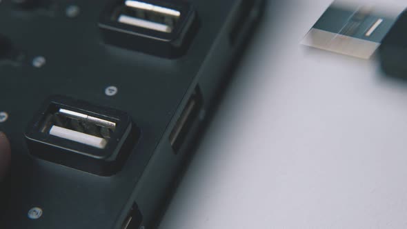 Man Takes Off Usb Cable From Black Hub on White Background