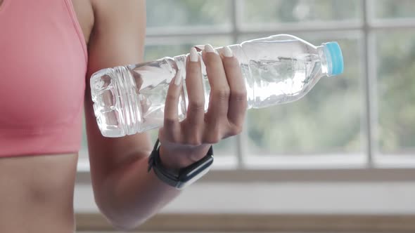 Close-up Asian woman in sportswear holding Water bottle weight exercise yoga workout.