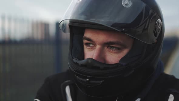 Portrait of Young Attractive Motorcyclist with Black Helmet on Street