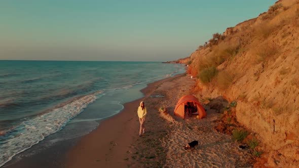 Aerial View Beautiful Sea Beach with Clay Cliff at Sunrise Happy Woman in Yellow Hoodie and Cute Dog