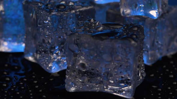 Close up ice cubes rotating on black background