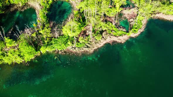 Emerald green Plitvive Lakes in Croatia, arial tilt-up reveal.