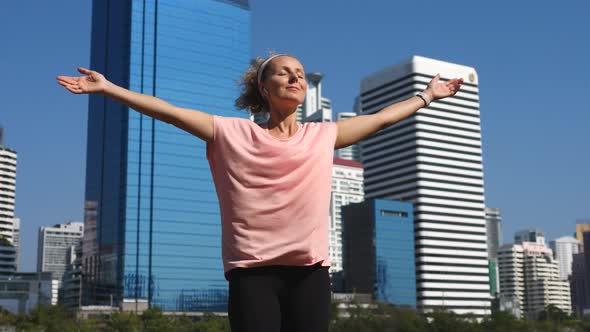Sportswoman Raising Arms To The Sky Exercising And Working Out Outdoors In City