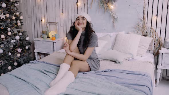 The Happy Young Woman Lying on the Bed, at Home in the Bedroom, Celebrates