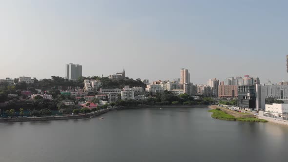 Drone shot flying above Sai Van Lake in Macau and approaching St. Lawrence's Parish area and chapel