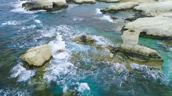 Aerial View of Waves Break on Rocks in a Blue Ocean Sea Waves on Beautiful Beach Aerial Drone Shot