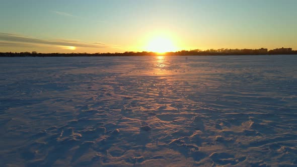 sun setting over the horizon in a frozen lake, amazing winter sunset in north america, nature outdoo