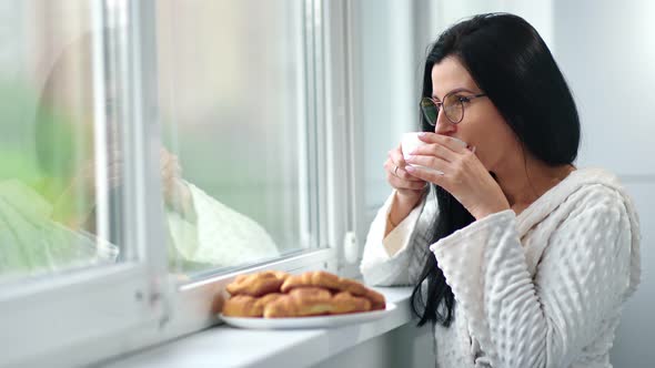 Smiling Domestic Woman Drinking Tea Holding Cup Looking at Window