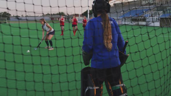 Female hockey players playing on the field