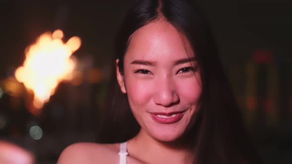 Young asian woman with sparklers is dancing and celebrating a new year. Fireworks,