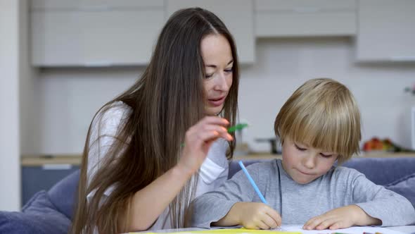 Positive Happy Mother Helping Son with Homework at Home